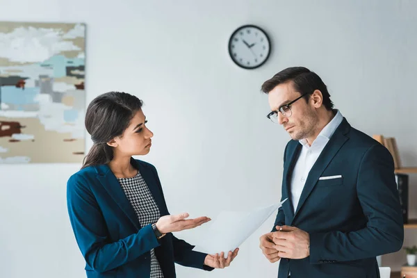 Colegas en trajes de negocios discutiendo sobre los detalles del contrato en la oficina moderna - foto de stock