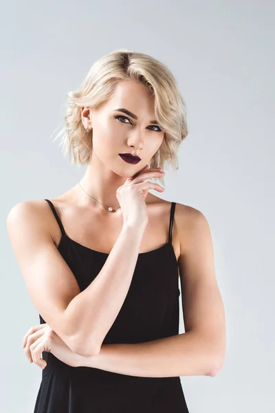 Blondes elegantes Mädchen im schwarzen Kleid, isoliert auf grau — Stockfoto