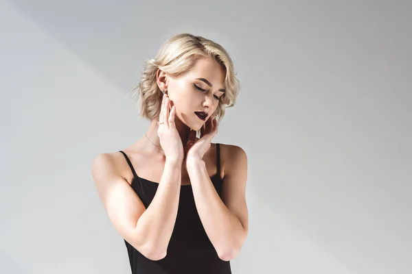 Menina macia posando em vestido preto elegante, isolado em cinza — Fotografia de Stock