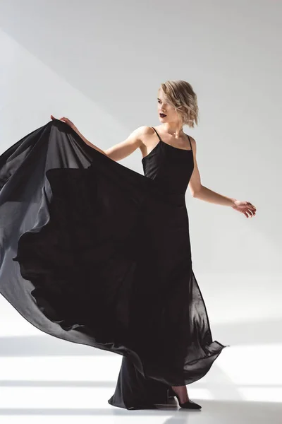 Menina bonita em vestido preto elegante, em cinza — Fotografia de Stock