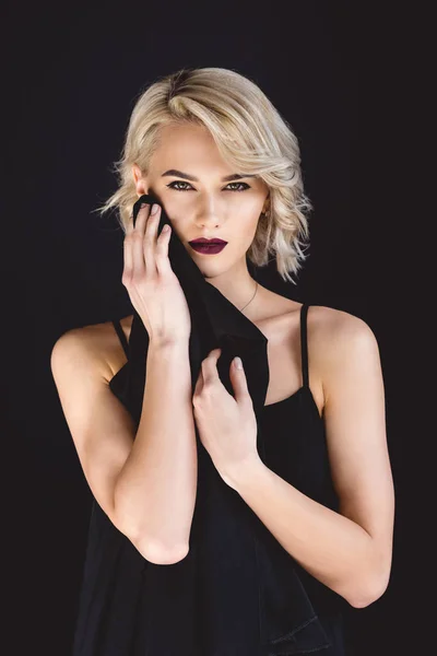 Attractive girl posing in elegant black dress, isolated on black — Stock Photo