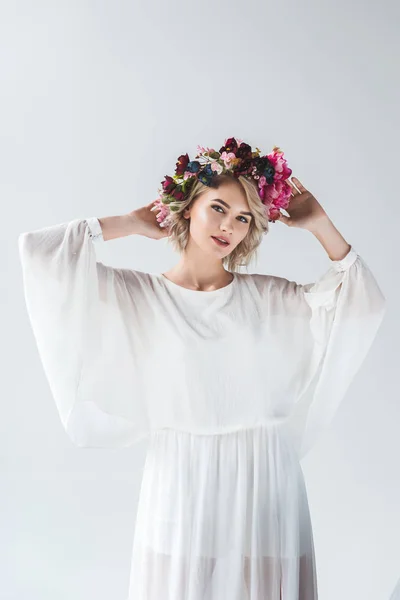 Schönes Model posiert in weißem Kleid und Blumenkranz, isoliert auf grau — Stockfoto