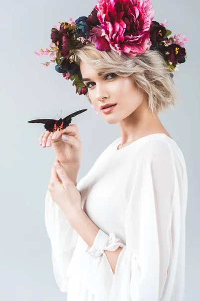 Belle fille posant en couronne avec papillon sur les mains, isolé sur gris — Photo de stock