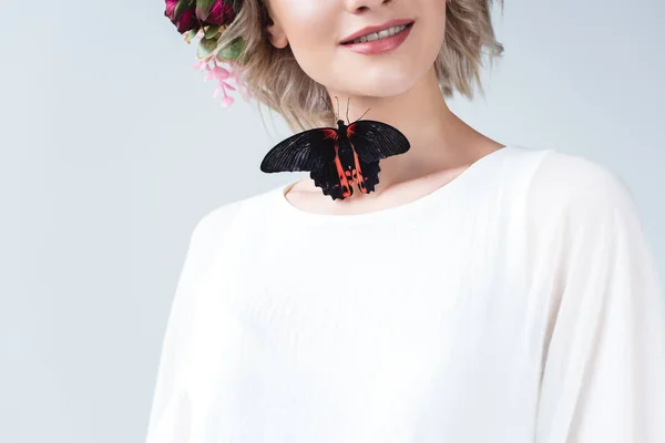 Vista recortada de chica feliz con hermosa mariposa viva en el cuello, aislado en gris - foto de stock