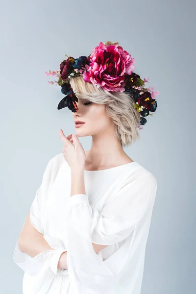 Jeune femme blonde posant en couronne florale avec papillon, isolée sur gris — Photo de stock