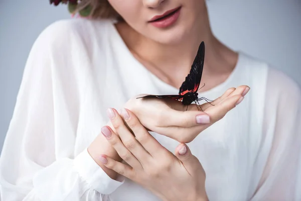 Cropped view of girl with alive butterfly on hand, isolated on grey — Stock Photo