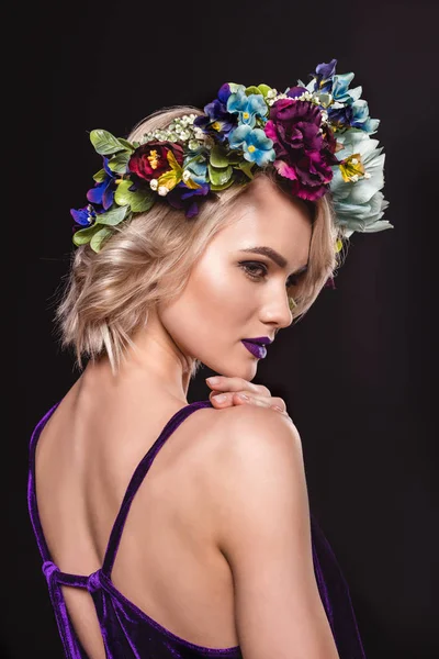 Modelo loira atraente posando em coroa floral, isolado em preto — Fotografia de Stock