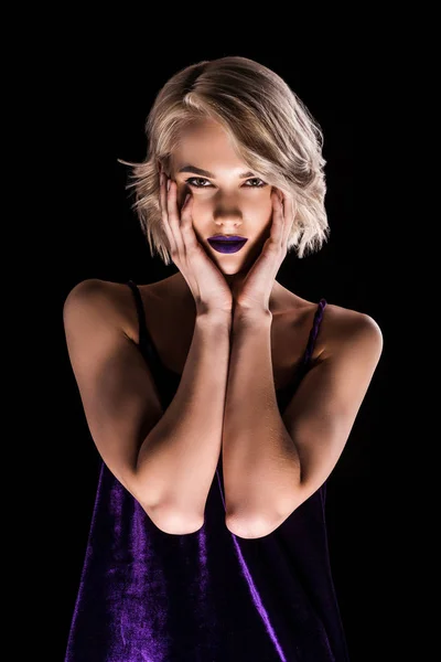 Привлекательная блондинка позирует в фиолетовом платье, изолированная от черного — стоковое фото