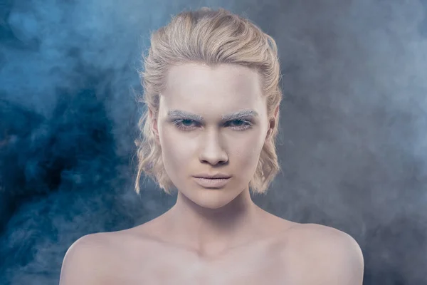 Portrait de fille blonde à la mode avec du maquillage blanc dans un studio fumé — Photo de stock