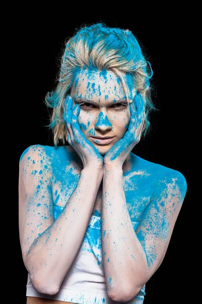Молодая женщина позирует в синей порошковой краске, изолированные на черном — стоковое фото