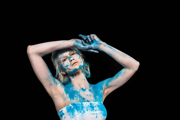 Beautiful girl posing in blue holi powder, isolated on black — Stock Photo