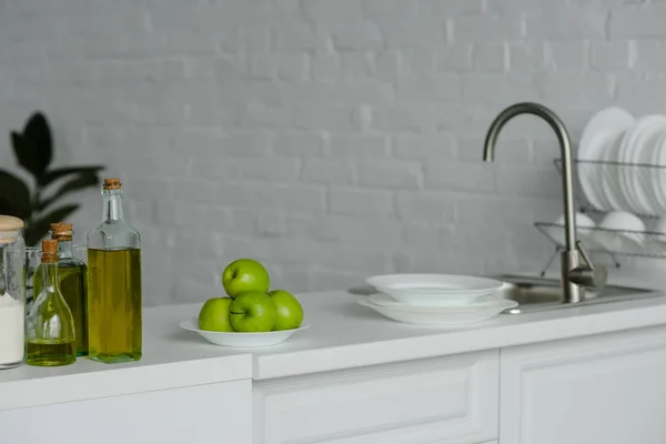 Спелые вкусные яблоки на тарелке на кухне — стоковое фото