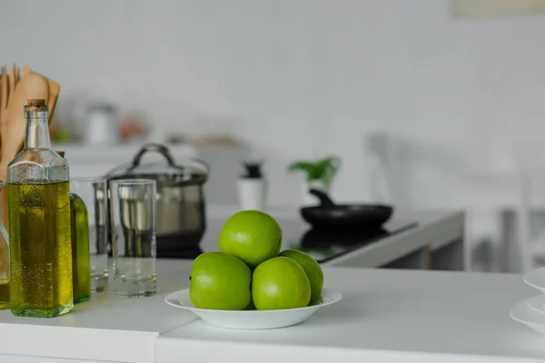 Спелые вкусные яблоки на тарелке на кухне счетчик — стоковое фото