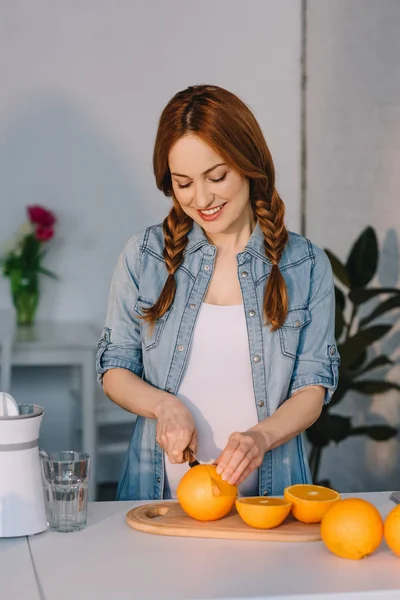 Pregnant cutting oranges — Stock Photo