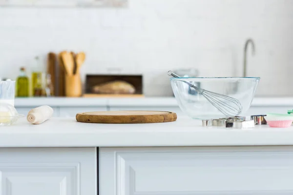 Rolling pin, cutting board and bowl with whisk on kitchen counter — Stock Photo