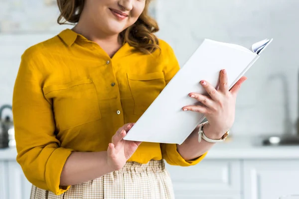 Cropped image of woman reading recipe book at kitchen — Stock Photo