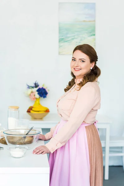 Vista laterale di bella donna in piedi al bancone della cucina — Foto stock