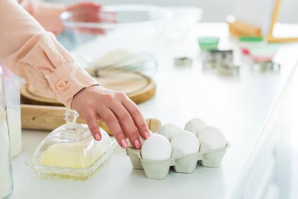 Abgeschnittenes Bild einer Frau, die in der Küche Eier für Teig nimmt — Stockfoto