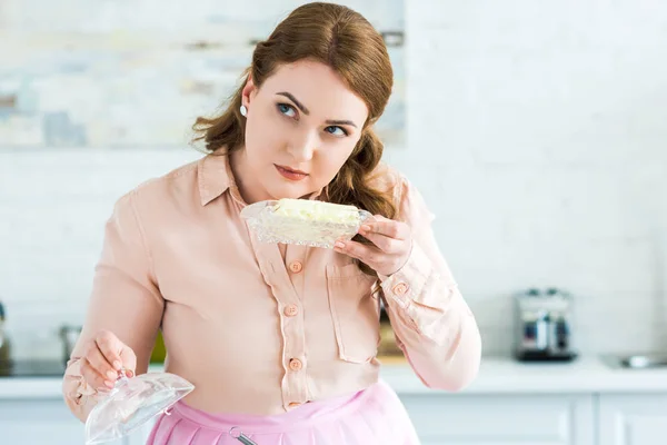 Schöne Frau schnüffelt Butter in der Küche — Stockfoto
