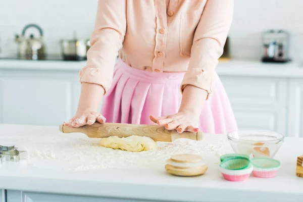 Imagem cortada de mulher rolando massa com rolo de pino na cozinha — Fotografia de Stock