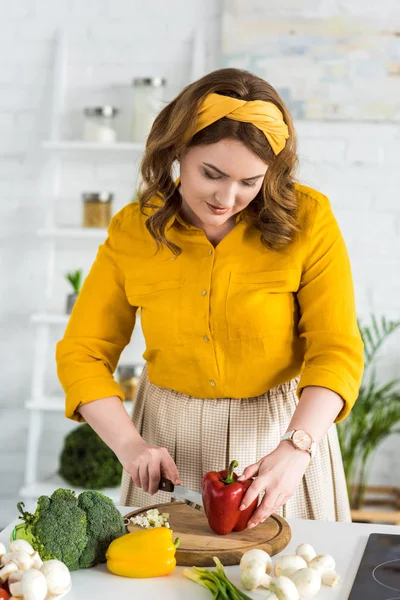 Belle femme coupe poivron rouge à la cuisine — Photo de stock