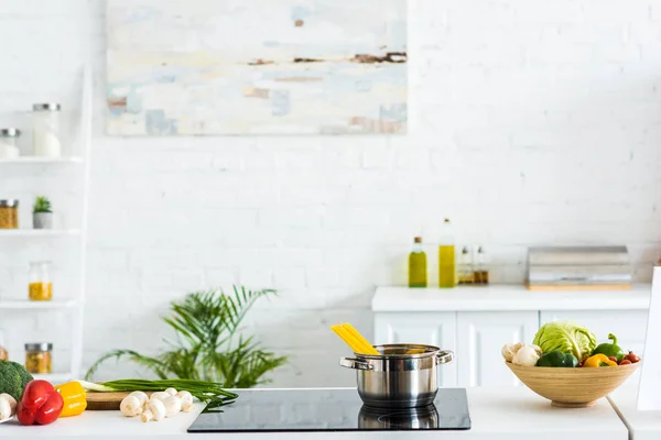 Intérieur de la cuisine moderne et lumineuse avec peinture sur mur et cuisinière électrique — Photo de stock