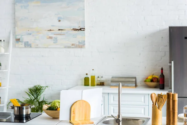 Interior of modern light kitchen with paint on wall — Stock Photo