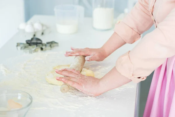 Abgeschnittenes Bild einer Frau, die Teig mit Nudelholz in der Küche rollt — Stockfoto