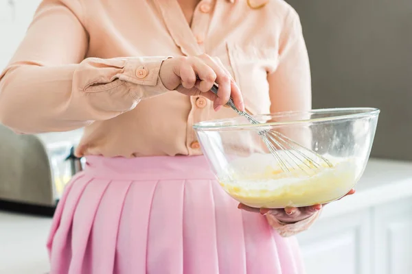 Обрезанный образ женщины, выбрасывающей тесто на кухню — стоковое фото
