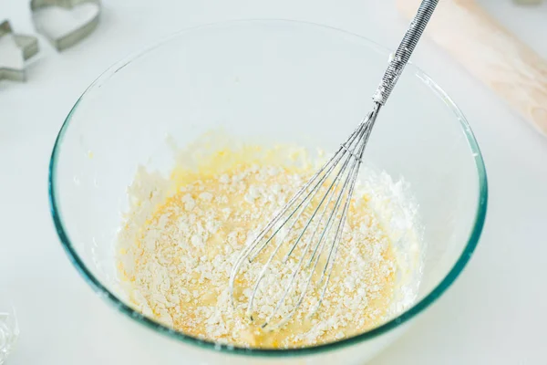 Vista ad angolo alto di ciotola con frusta e pasta in cucina — Foto stock