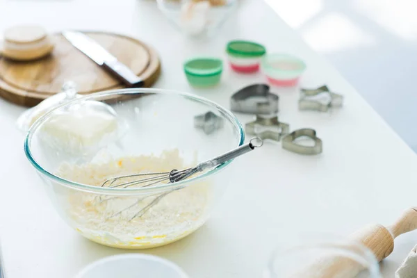 Dough with whisk in bowl on kitchen counter — Stock Photo