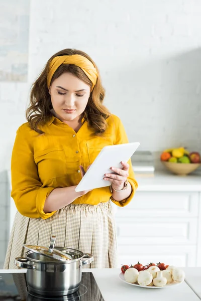 Beautiful woman using tablet in kitchen — Stock Photo