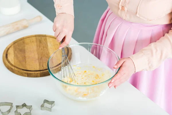 Imagem cortada de mulher batendo massa na tigela na cozinha — Fotografia de Stock