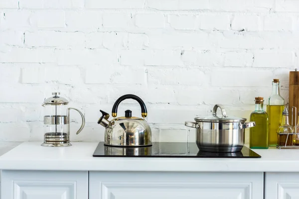 Чайник и кастрюля на электрической плите на кухне — стоковое фото