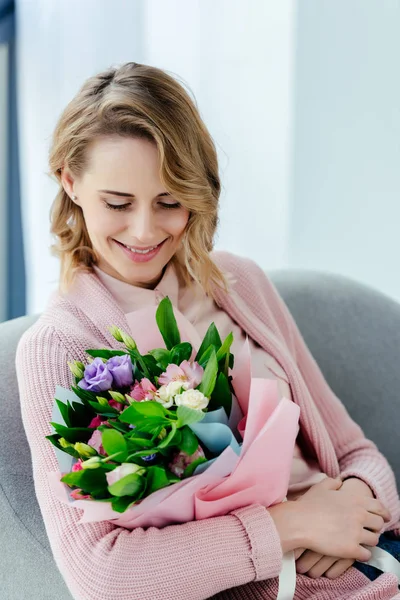 Portrait of beautiful smiling woman with bouquet of flowers — Stock Photo