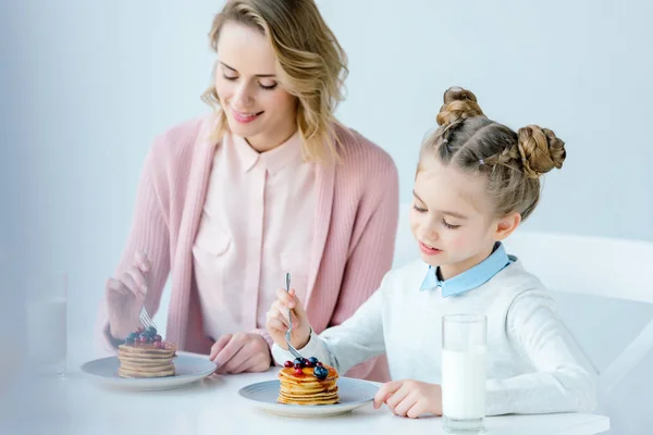 Foco seletivo de mãe e filha tomando café da manhã juntos na mesa — Fotografia de Stock