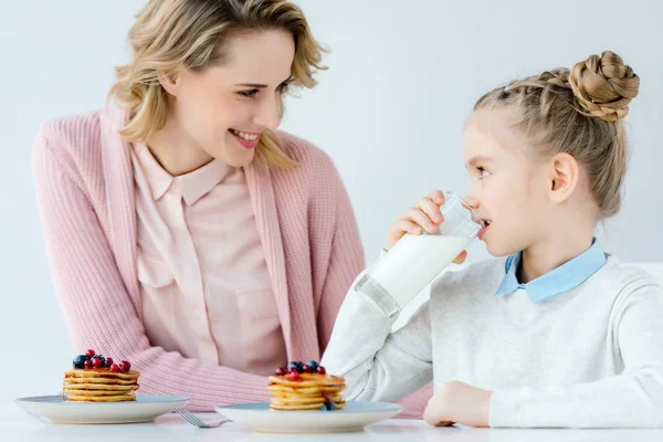 Happy mother and daughter having breakfast together at table — Stock Photo