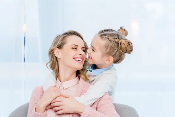 Glückliche Tochter umarmt lächelnde Mutter zu Hause — Stockfoto