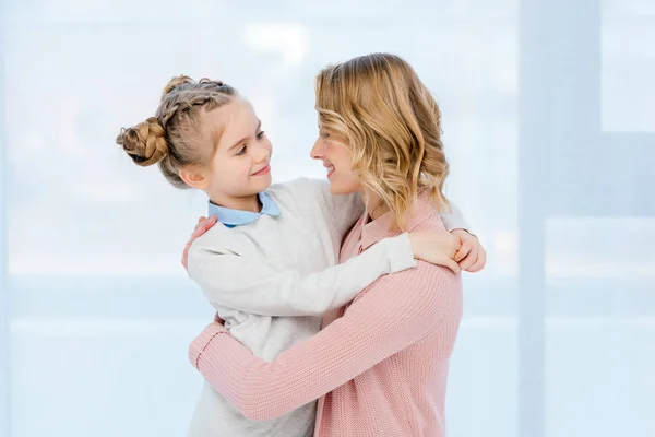Happy mother and daughter hugging at home — Stock Photo