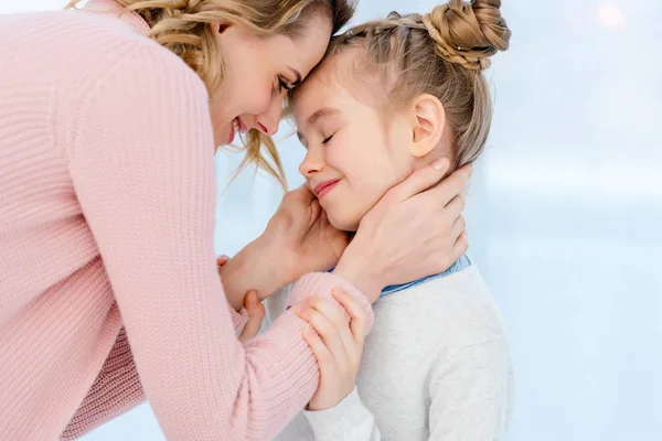 Felice madre abbracciare figlia a casa — Foto stock