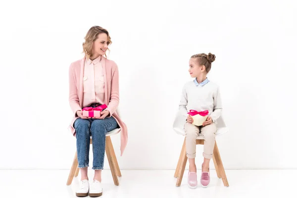 Mãe e filha sentadas em cadeiras e segurando caixas presentes, conceito feliz dia das mães — Fotografia de Stock