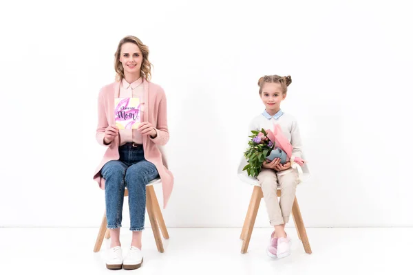 Mère et fille assis sur des chaises et regardant la caméra sur la fête des mères heureuses — Photo de stock