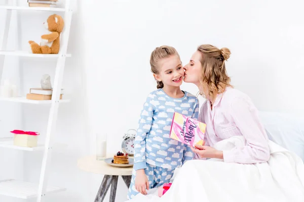 Mutter küsst Tochter für Geschenke am glücklichen Muttertag — Stockfoto