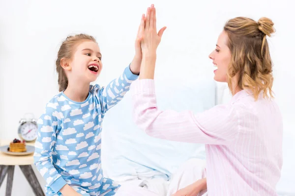 Mother and daughter giving high five at home — Stock Photo