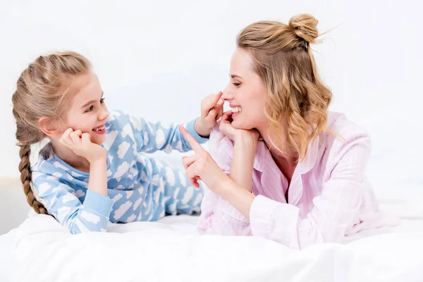 Mutter und Tochter amüsieren sich und rühren zu Hause mit den Fingern Nasen an — Stockfoto