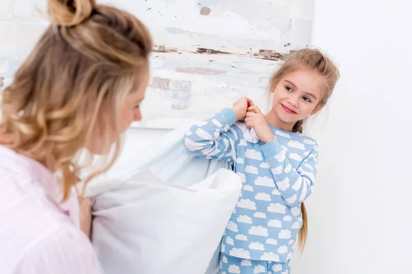 Mãe e filha se divertindo e brigando com travesseiros em casa — Fotografia de Stock