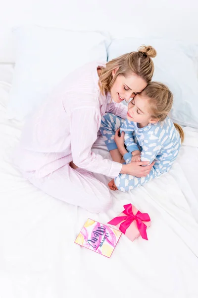 Alto ángulo vista de la madre abrazando hija en casa en feliz día de las madres - foto de stock