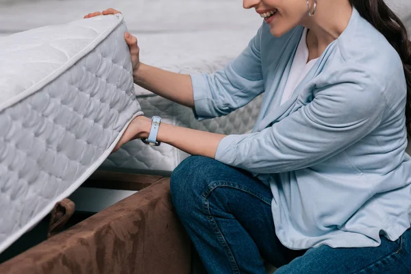 Cropped shot of smiling woman choosing orthopedic mattress in furniture store — Stock Photo