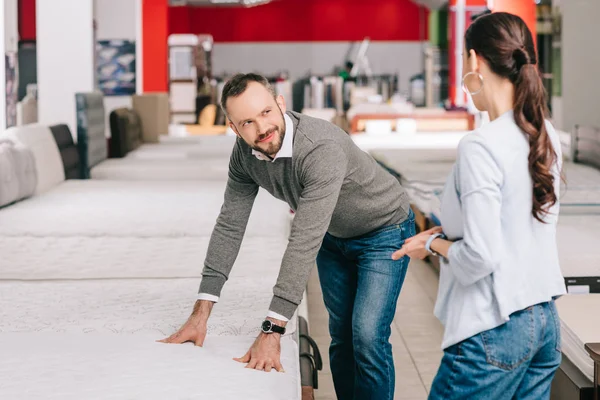 Couple choosing mattress together in furniture shop — Stock Photo