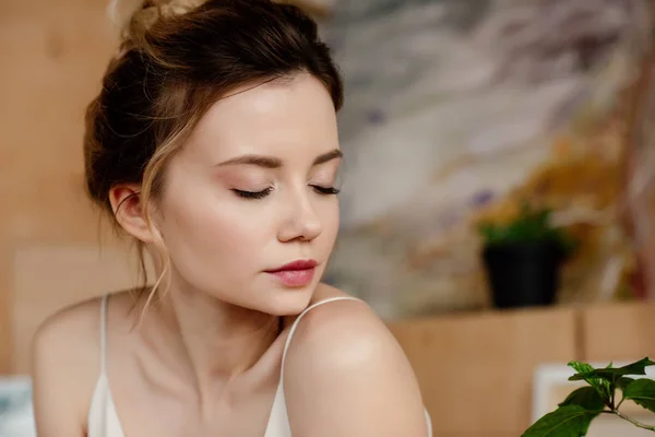 Close-up portrait of beautiful tender girl with closed eyes in art studio — Stock Photo